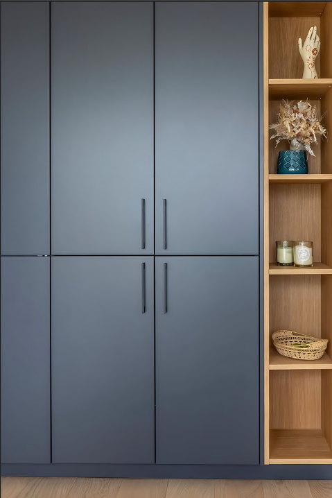Armário planejado em madeira com portas azul fosco e nichos decorativos