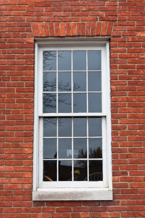 Janelas de madeira em edifício monumental com colunas e detalhes arquitetônicos