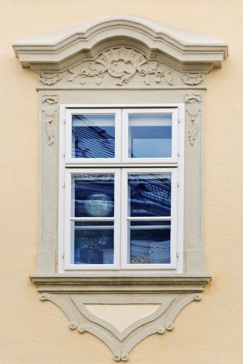 Janelas de madeira com sacada e persianas em fachada residencial tradicional
