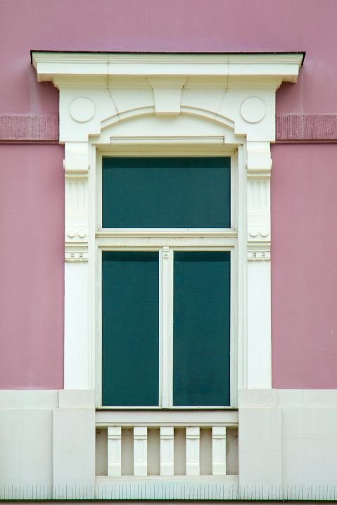 Janelas de madeira em edifício histórico de tijolos com arquitetura clássica europeia