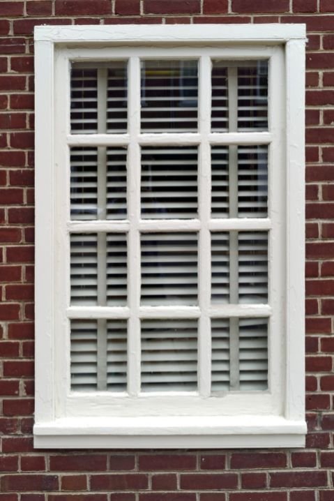 Janelas de madeira clássicas com moldura ornamental em fachada histórica