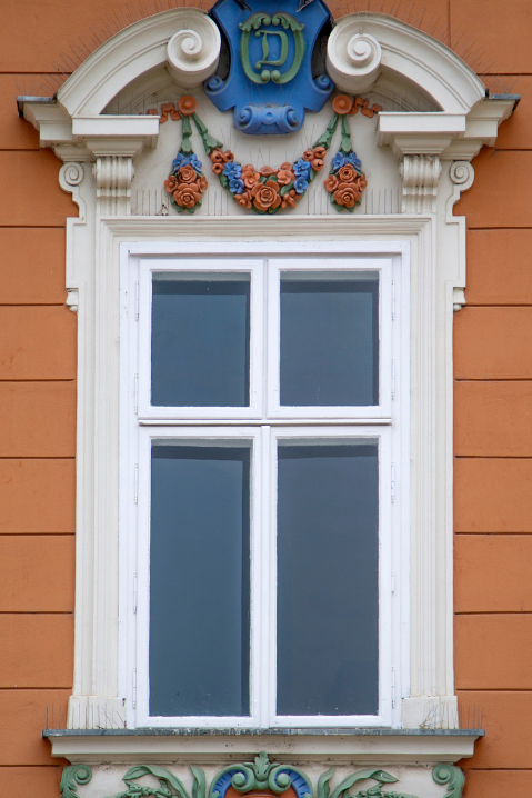 Janelas de madeira clássicas com moldura ornamental em fachada histórica