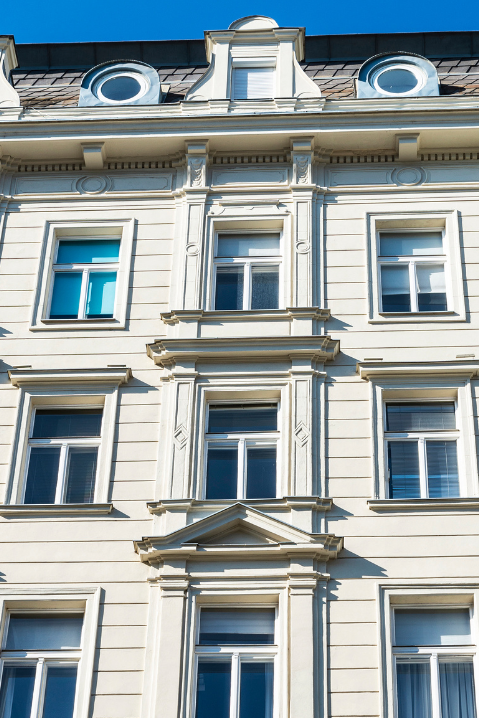 Janelas de madeira clássicas com molduras decorativas em fachada residencial elegante
