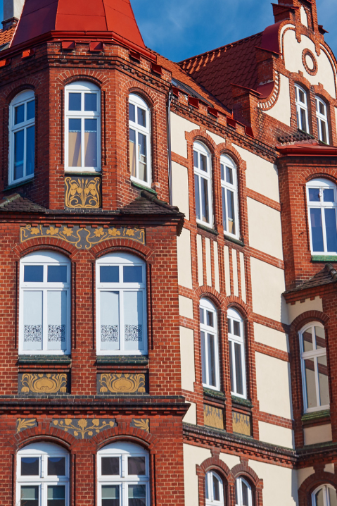Janelas de madeira em edifício histórico de tijolos com arquitetura clássica europeia