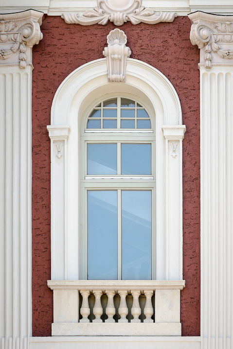 Janelas de madeira arqueadas com detalhes arquitetônicos em estilo neoclássico